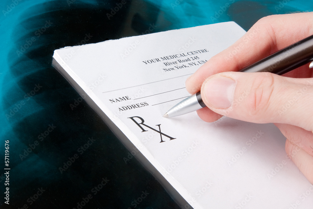Doctor filling in empty medical prescription on Xray photo Doctor filling in empty medical prescription on Xray photo