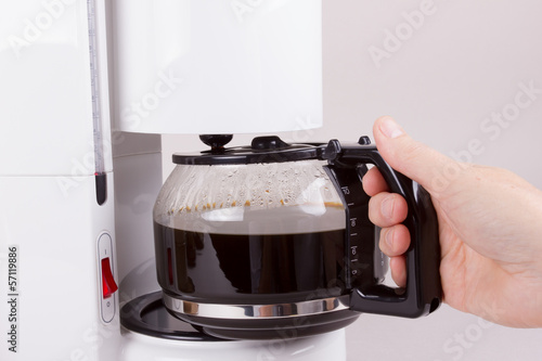 Foto Kaffeekanne aus Kaffeeautomat nehmend