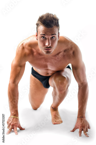 Handsome young muscular man ready to sprint and run