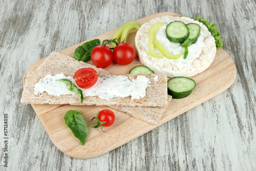 Tasty crispbreads with vegetables on wooden background Tasty crispbreads with vegetables on wooden background