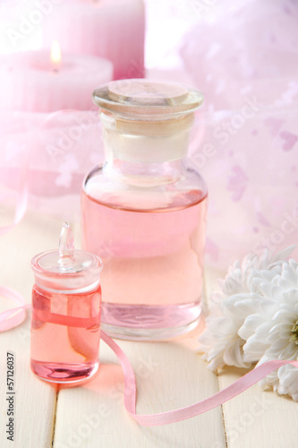 Glass bottle with color essence, on wooden background