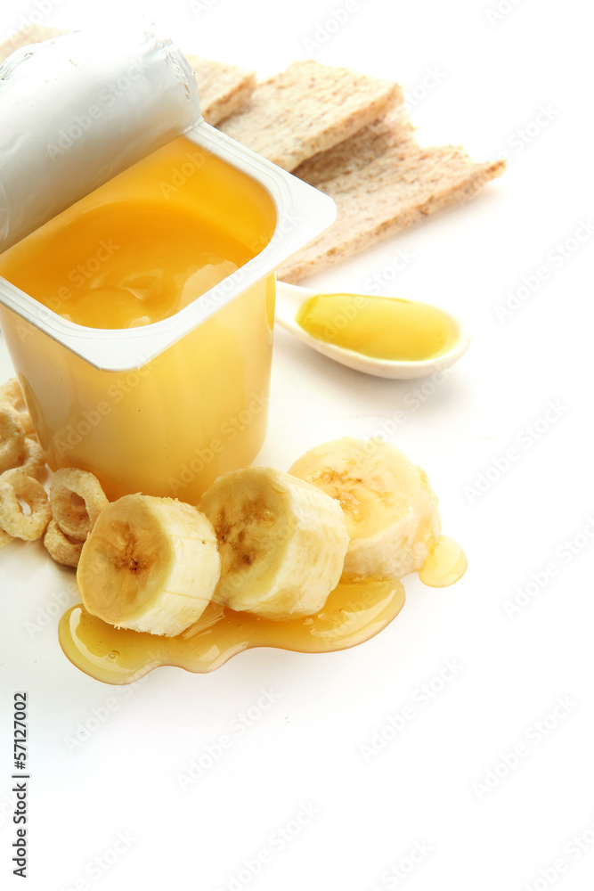 Tasty dessert in open plastic cup and banana, isolated on white Tasty dessert in open plastic cup and banana, isolated on white