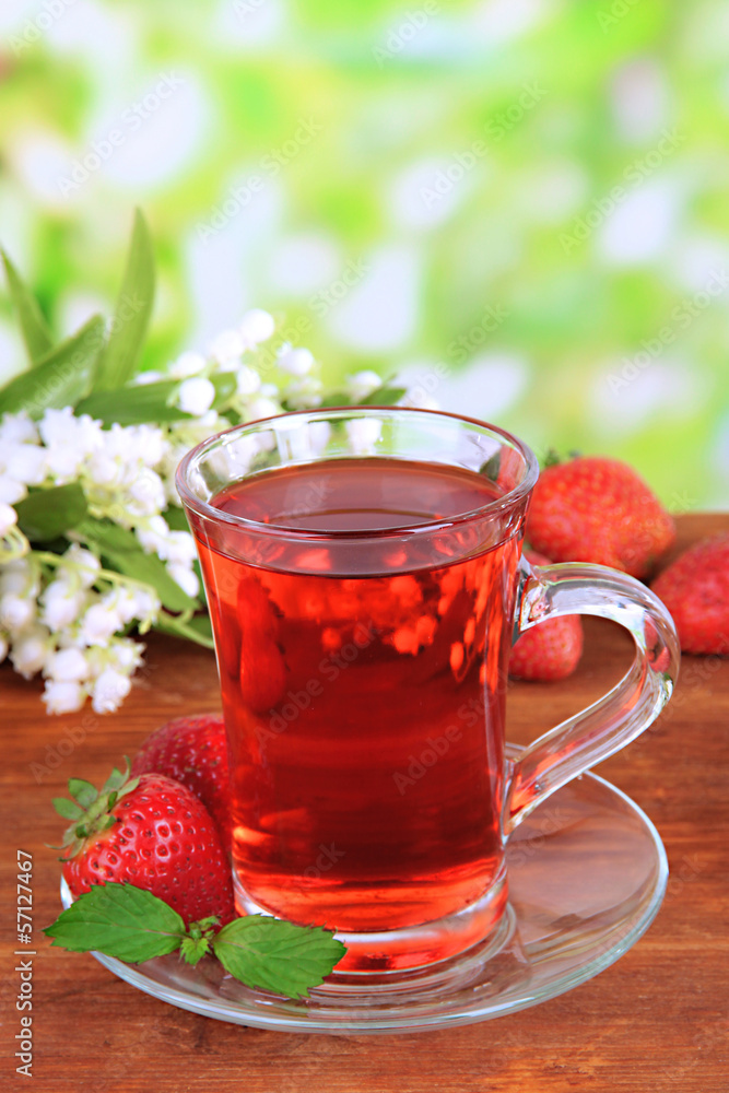 Delicious strawberry tea on table on bright background Delicious strawberry tea on table on bright background