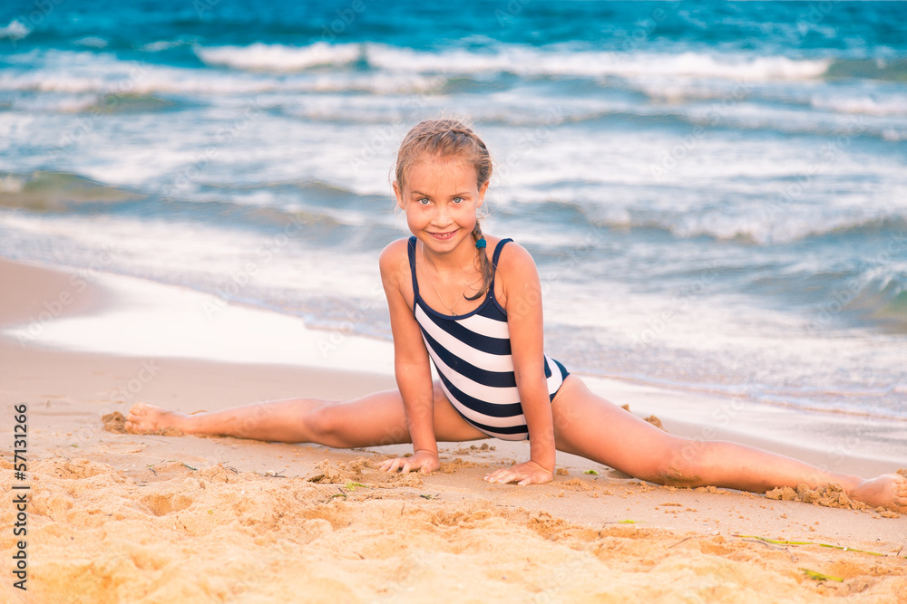 Beautiful little girl excercising on the beach Beautiful little girl excercising on the beach
