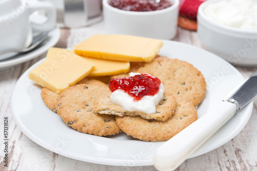 crackers with cheese, cream and jam for breakfast, close-up