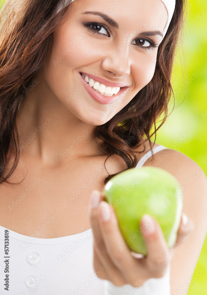 Woman in fitness wear with apple, outdoors Woman in fitness wear with apple, outdoors
