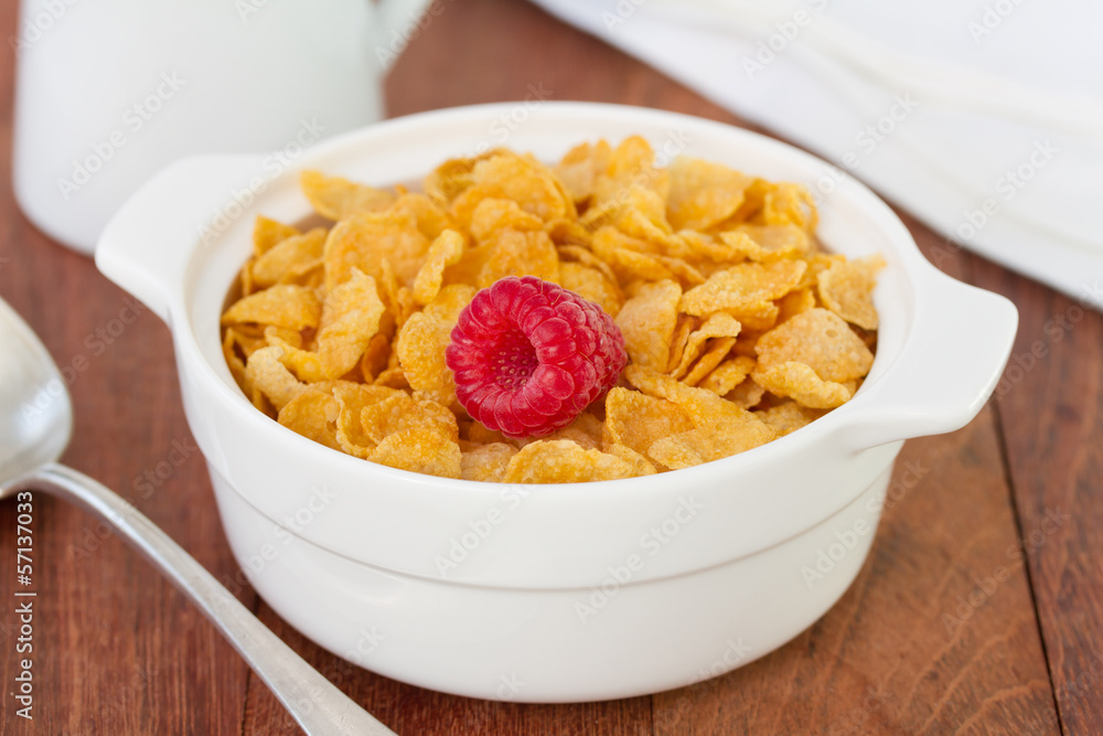 cornflakes with raspberry in white bowl cornflakes with raspberry in white bowl