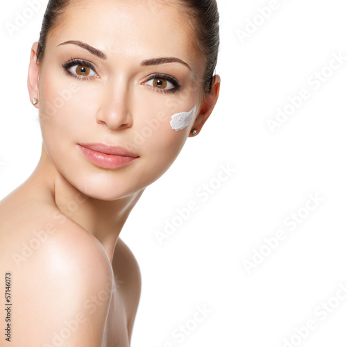 Beauty face of woman with cosmetic cream on face