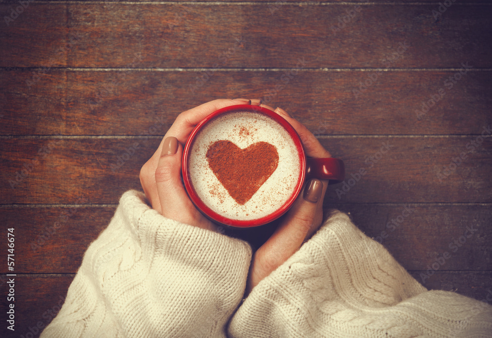 woman holding hot cup of coffee, with heart shape - obrazy, fototapety, plakaty 