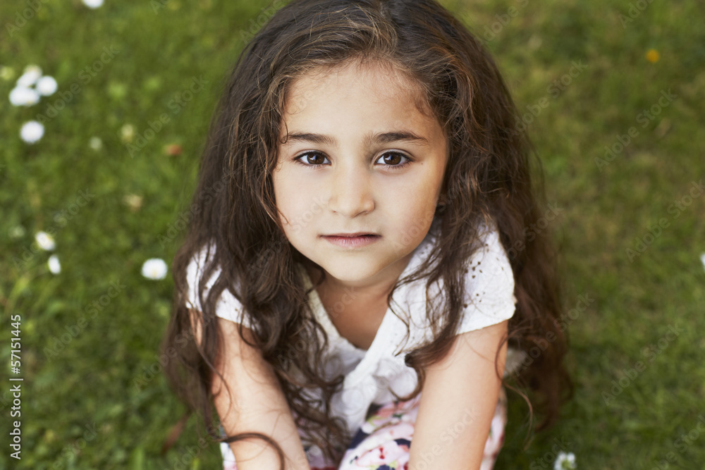 Young girl sitting on grass, portrait Young girl sitting on grass, portrait