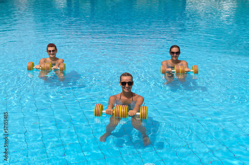 Happy active fitness people doing exercise with aqua dumbbell