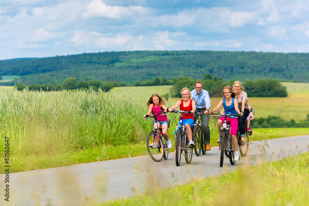 Obraz premium Family cycling in summer in rural landscape
