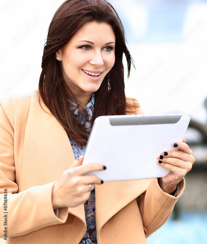 Businesswoman in coat working on digital tablet out of office Businesswoman in coat working on digital tablet out of office