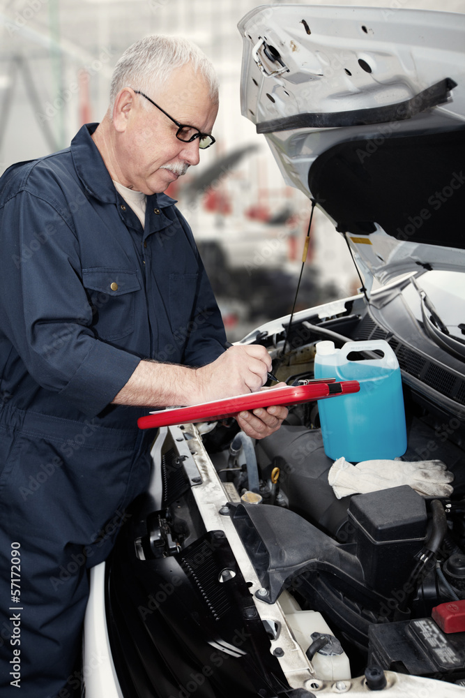 Auto mechanic checking engine.