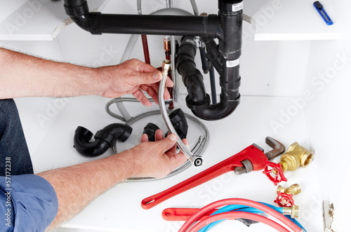Hands of Plumber with a wrench.