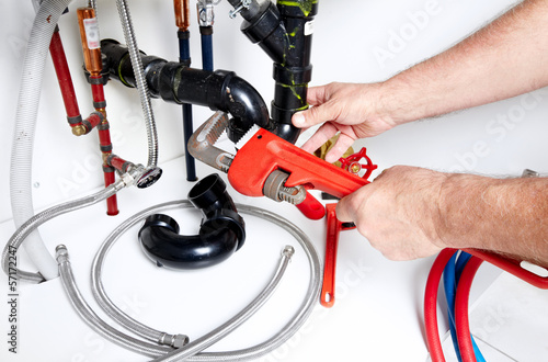 Hands of Plumber with a wrench.