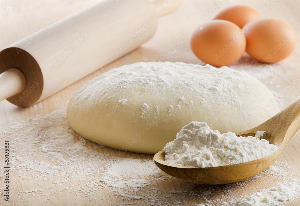 Dough with rolling pin on wooden table Dough with rolling pin on wooden table