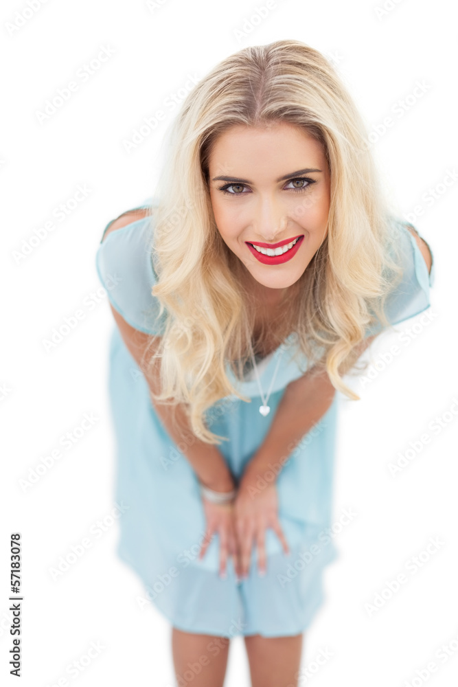 Happy blonde model in blue dress posing hands on the thighs Happy blonde model in blue dress posing hands on the thighs