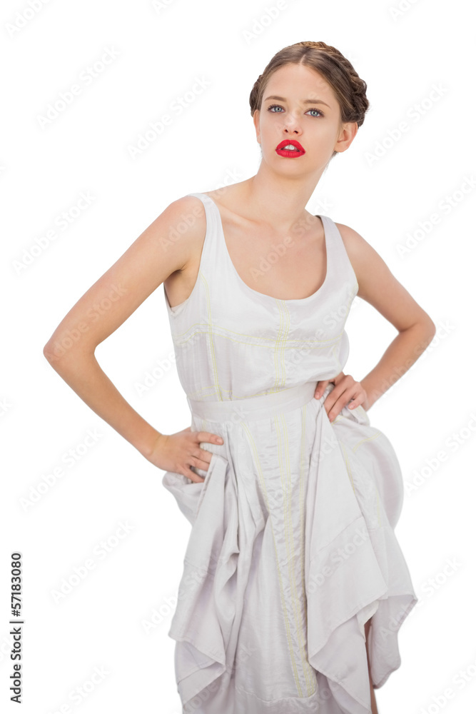 Severe model in white dress posing hands on the hips Severe model in white dress posing hands on the hips