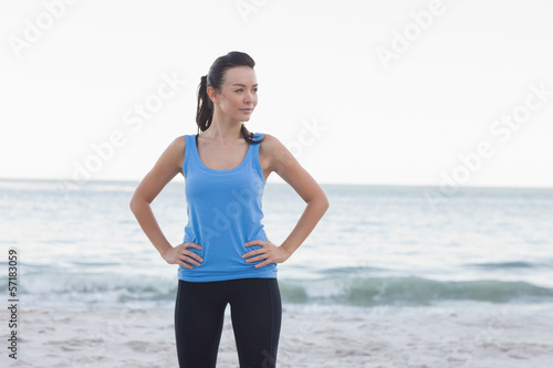 Happy brunette woman standing in front of the sea