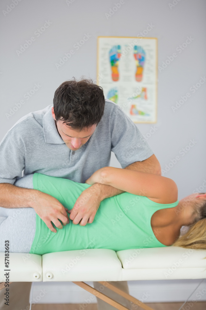 Fototapeta premium Handsome physiotherapist massaging patients back