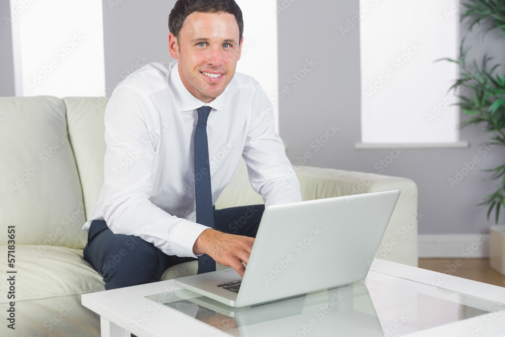 Cheerful handsome businessman working at laptop Cheerful handsome businessman working at laptop