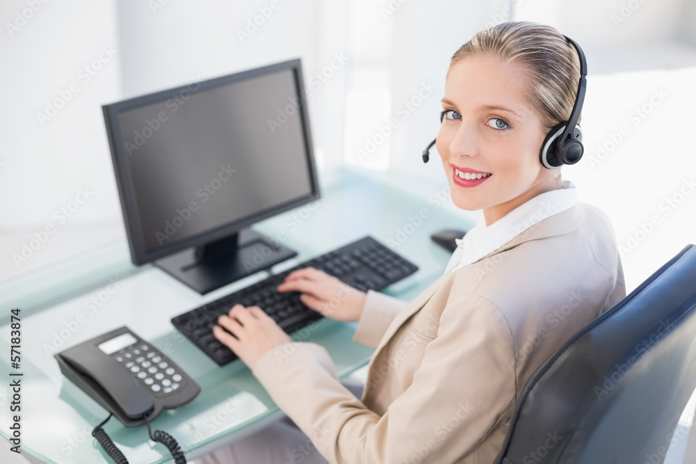 Smiling blonde call centre agent typing Smiling blonde call centre agent typing