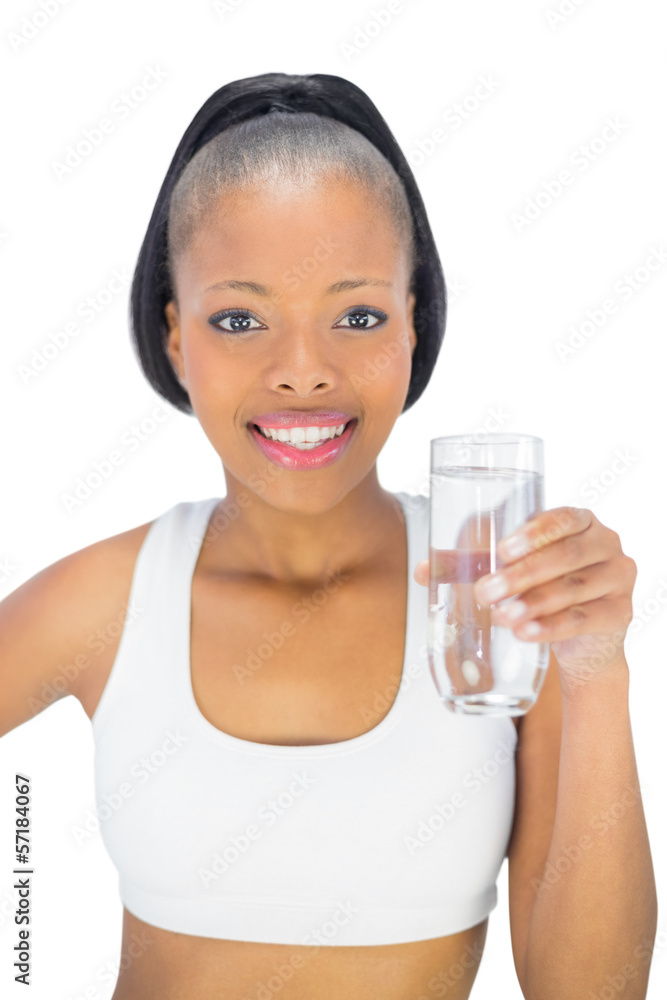 Fit woman holding glass of water while looking at camera Fit woman holding glass of water while looking at camera