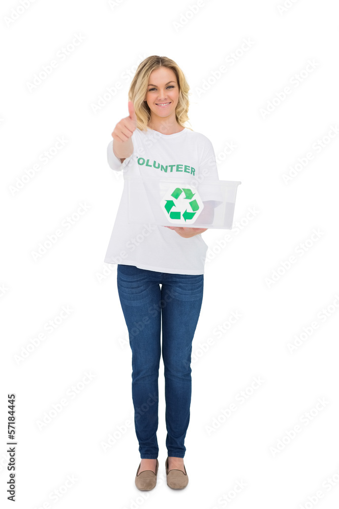 Smiling blonde volunteer holding recycling box giving thumb up t Smiling blonde volunteer holding recycling box giving thumb up t