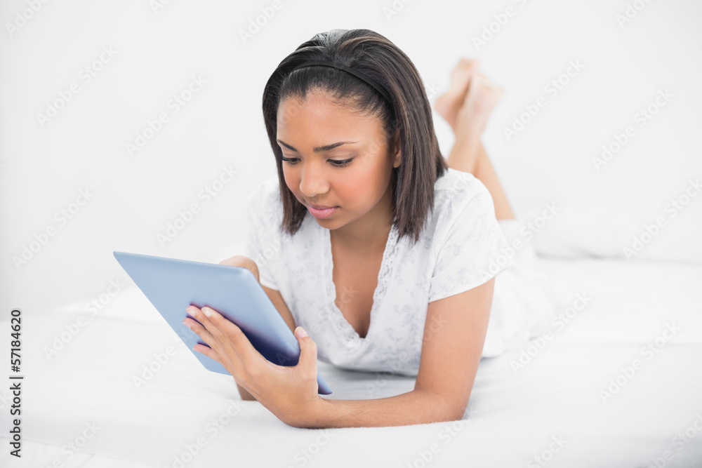 Thinking young dark haired model using a tablet pc Thinking young dark haired model using a tablet pc