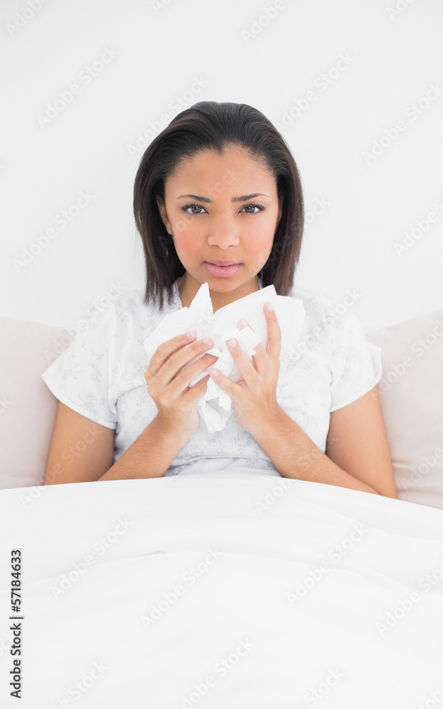 Sad young dark haired model holding tissues Sad young dark haired model holding tissues