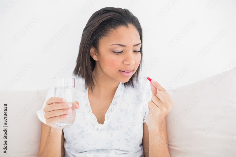 Unsmiling young dark haired model taking medication Unsmiling young dark haired model taking medication
