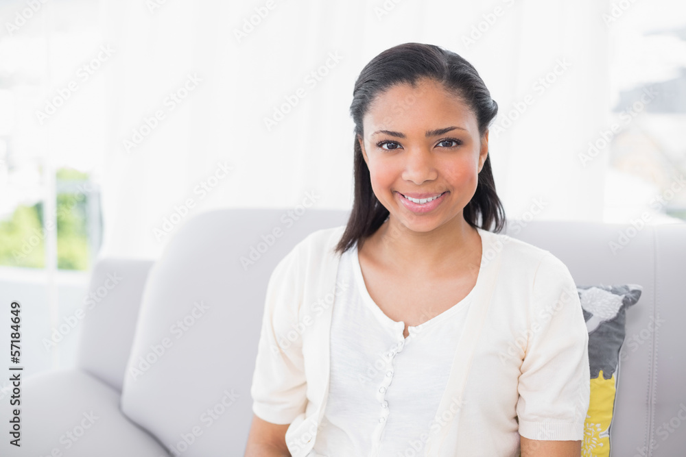 Smiling young dark haired woman in white clothes looking at came Smiling young dark haired woman in white clothes looking at came
