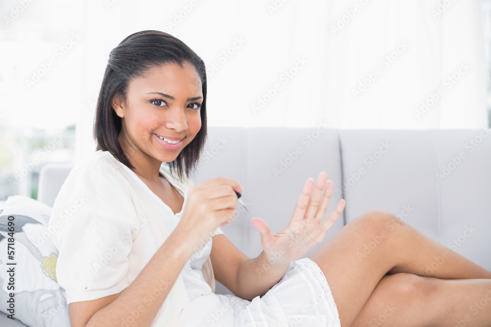 Gorgeous young dark haired woman in white clothes applying nail Gorgeous young dark haired woman in white clothes applying nail