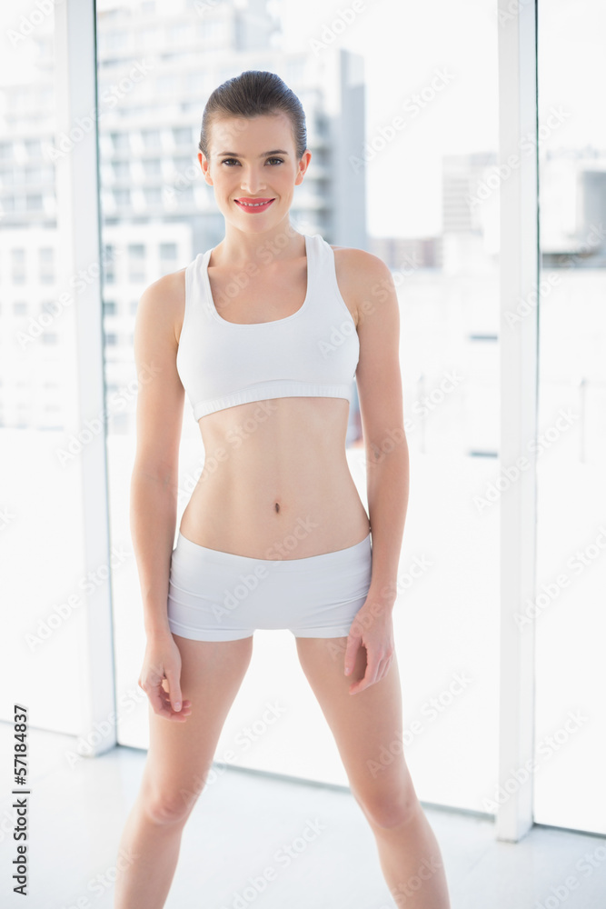 Lovely fit brown haired model in sportswear posing looking at ca Lovely fit brown haired model in sportswear posing looking at ca