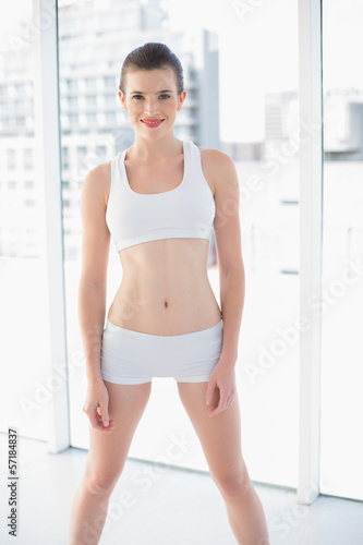 Lovely fit brown haired model in sportswear posing looking at ca