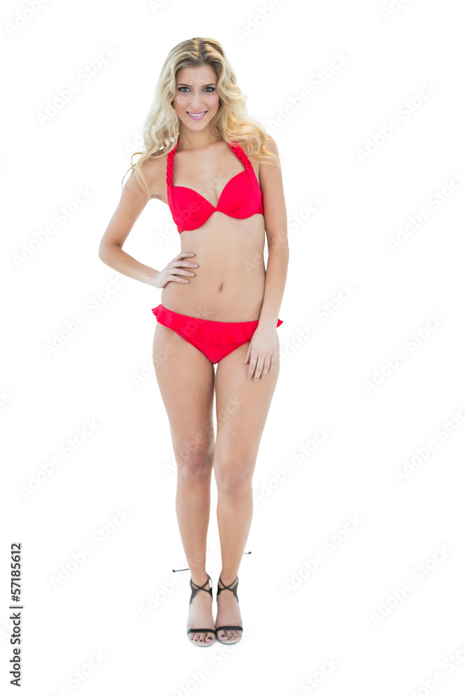 Gleeful blonde model posing with hand on hips wearing red bikini Gleeful blonde model posing with hand on hips wearing red bikini
