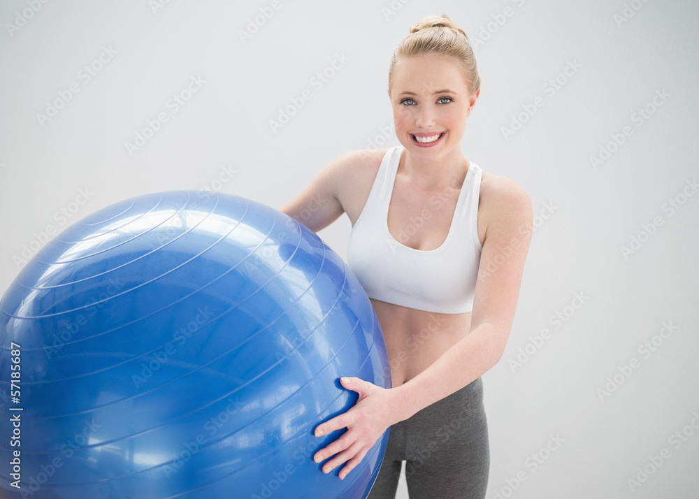 Cheerful sporty blonde holding exercise ball Cheerful sporty blonde holding exercise ball