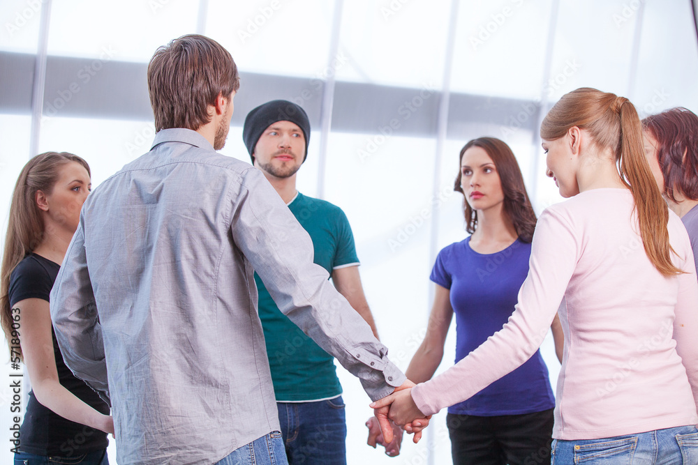 Group of people standing in circle.