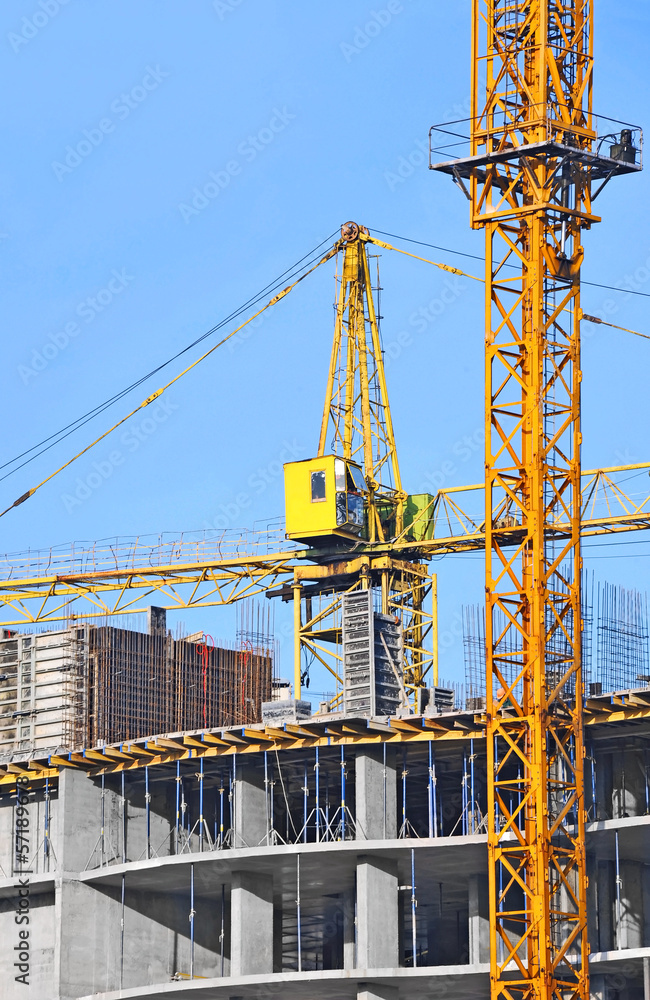Crane and building construction site against blue sky Crane and building construction site against blue sky