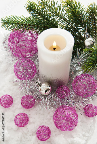 White candle and Christmas decorations around