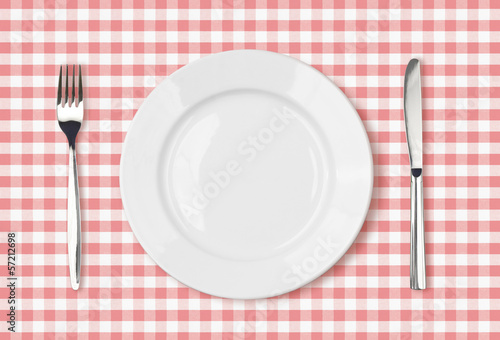 empty dinner plate top view on pink picnic table cloth