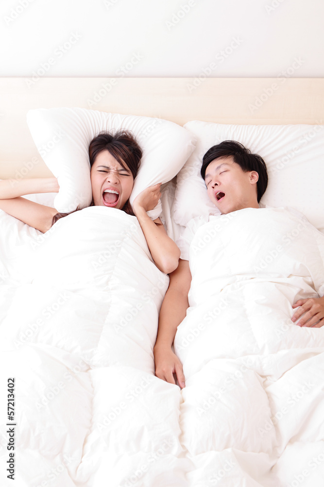 Young woman disturbed by the snores of her husband Young woman disturbed by the snores of her husband
