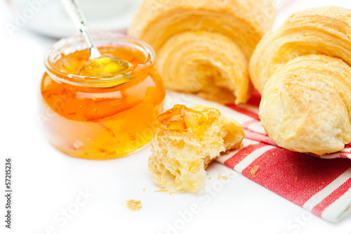 Close up of croissant bite and marmalade