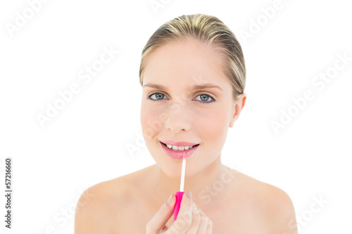 Cheerful fresh blonde woman applying gloss