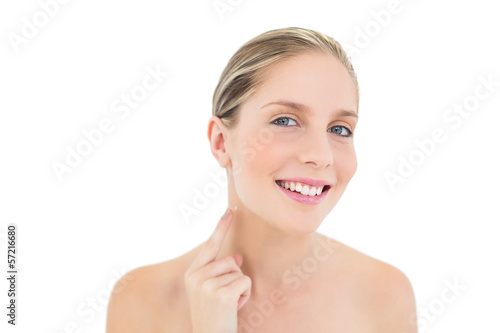 Pleased fresh blonde woman pointing her neck with her finger