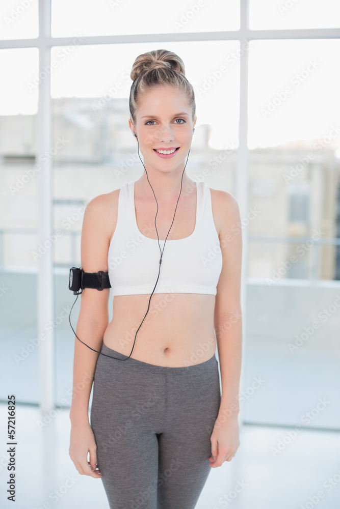 Smiling sporty blonde listening to music