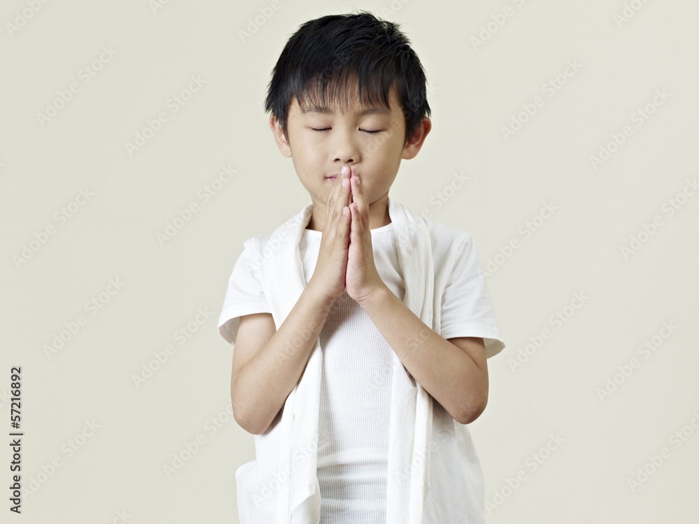 little asian boy praying with clasped hands little asian boy praying with clasped hands
