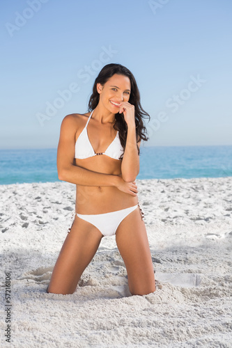 Cheerful sexy woman in white bikini posing