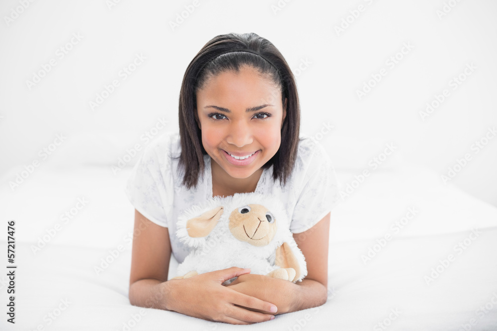 Pretty young dark haired model cuddling a plush sheep Pretty young dark haired model cuddling a plush sheep